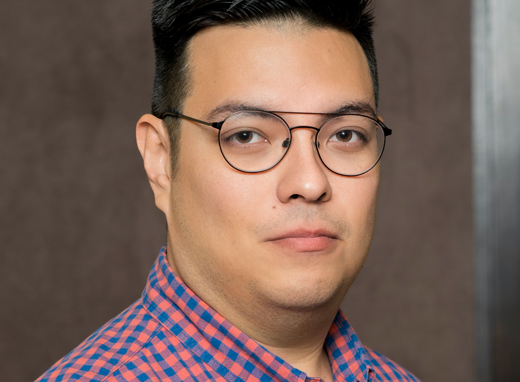 Dr. Victor Del Hierro, a tan-skinned man with dark hair and glasses, wearing a green and blue checkered shirt.