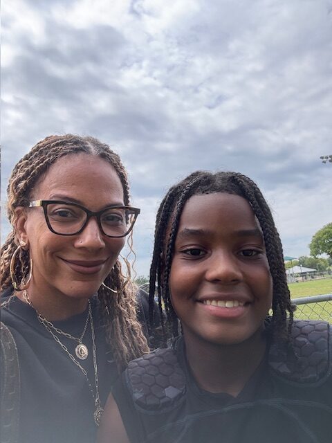 Kelly and her son A pose for a selfie in front of a sports field